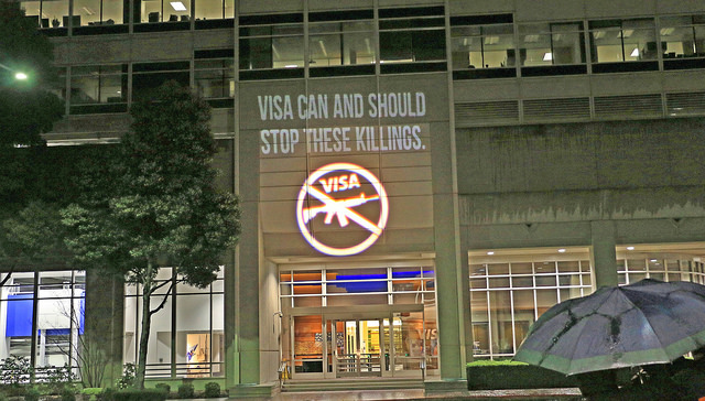 Photo of a light projection on Visa's Foster City headquarters that reads "Visa can and should stop these killings"
